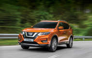 Orange Nissan X-Trail driving on tar road