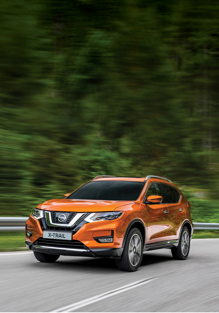 Orange Nissan X-Trail driving on tar road