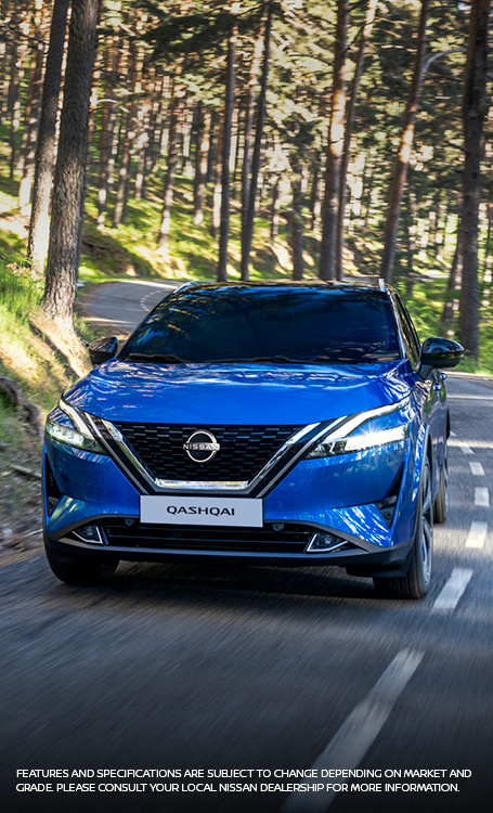 Blue Qashqai driving on tar road through a forest